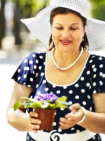 Mulher velha feliz com flor ao ar livre . — Fotografia de Stock