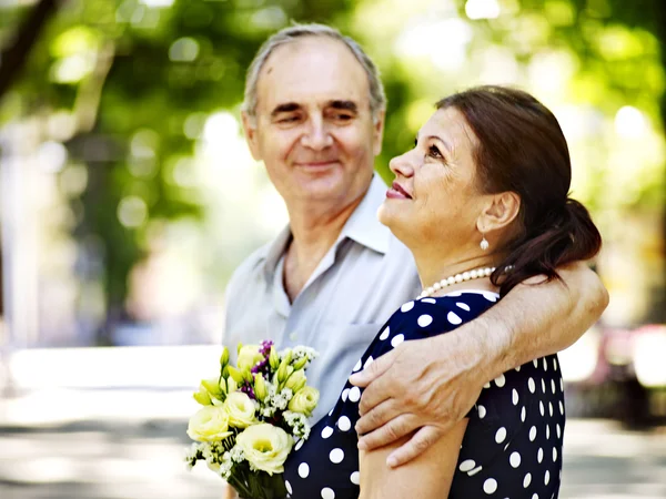 Glückliches altes Paar mit Blume. — Stockfoto