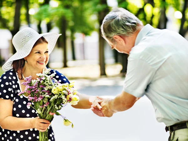 Glückliches altes Paar mit Blume. — Stockfoto