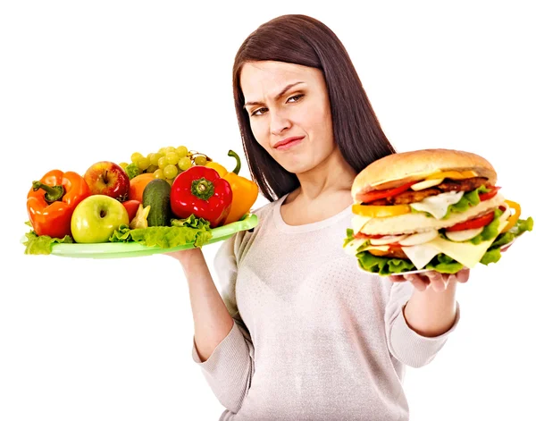Kobieta wybierając między owoców i hamburger. — Zdjęcie stockowe
