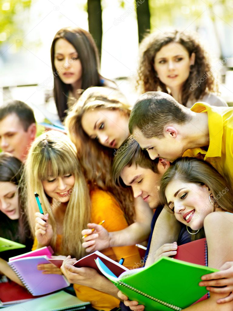 Group student with notebook on bench outdoor.