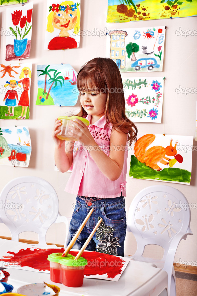 Child girl with clay in play room.