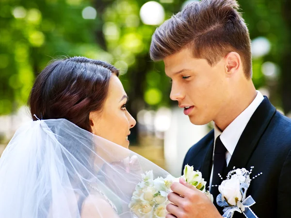 Bruden och brudgummen håller blomma utomhus. — Stockfoto