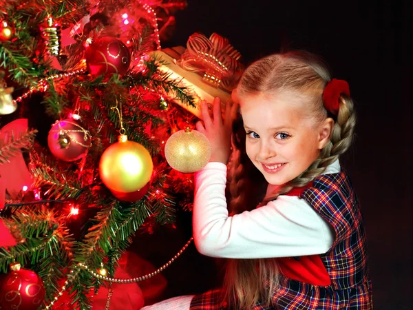 Kind mit Geschenkbox in der Nähe des Weihnachtsbaums. — Stockfoto