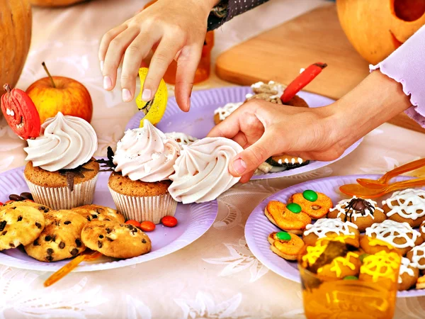 Halloween table with trick or treat and child hands. — Stock Photo, Image