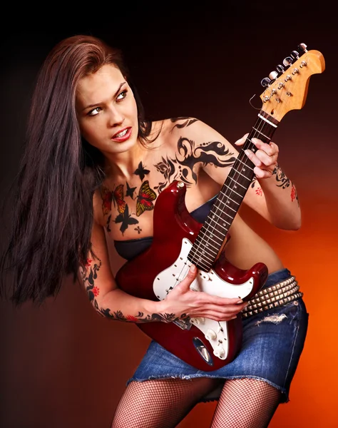 Aggressive girl with tattoo playing guitar. — Stock Photo, Image