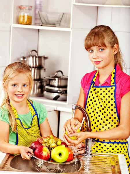 Barn tvätta frukt på kök. — Stockfoto