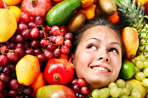 Girl in group of fruit. — Stock Photo, Image