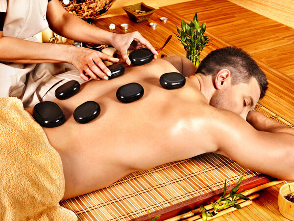Man getting stone therapy massage .