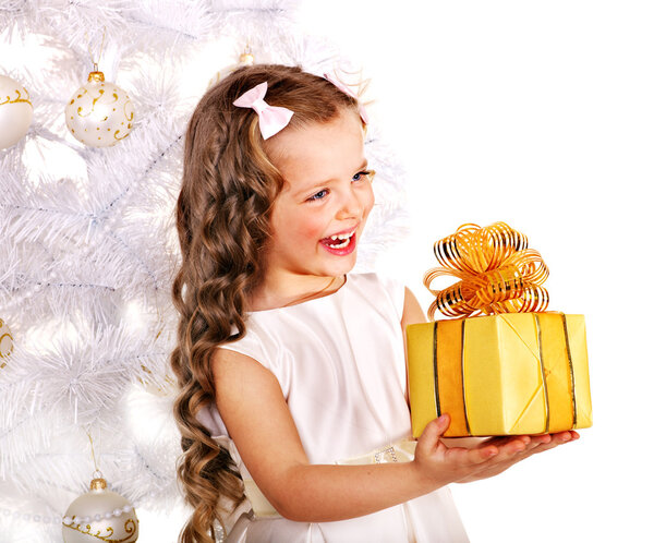 Child with gift box near white Christmas tree.