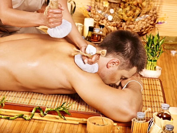 Man getting herbal ball massage treatments . — Stock Photo, Image