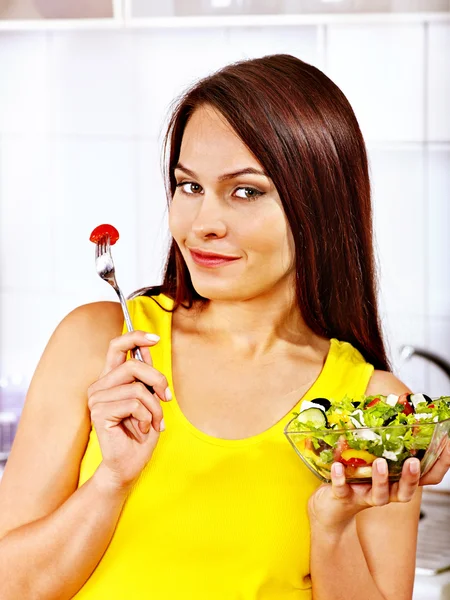 Femme manger de la salade à la cuisine . — Photo