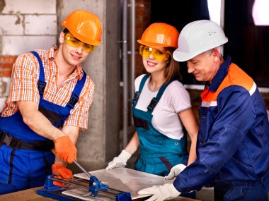 Group people builder cutting ceramic tile. clipart