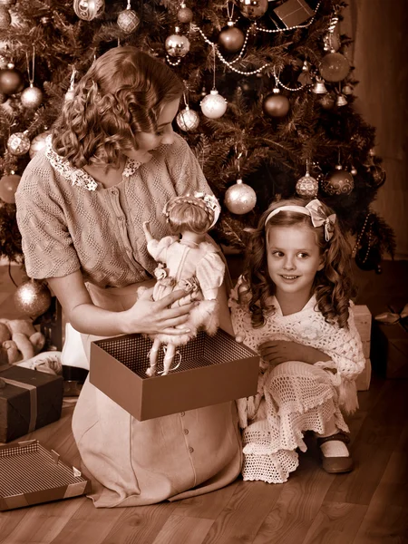 Kind mit Mutter bekommt Geschenke unterm Weihnachtsbaum. — Stockfoto