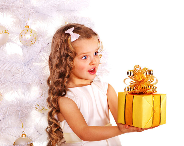 Child with gift box near white Christmas tree.