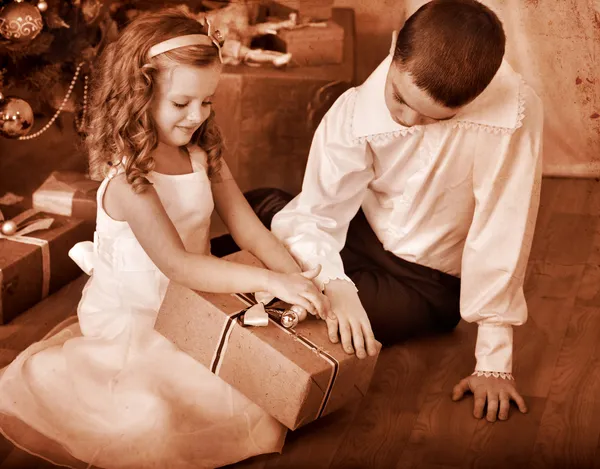 Niños recibiendo regalos bajo el árbol de Navidad . —  Fotos de Stock