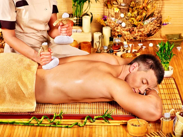 Man getting herbal ball massage treatments . — Stock Photo, Image