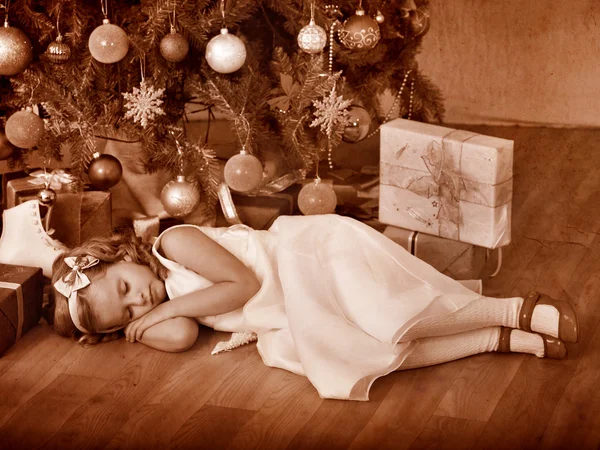 Bambino che dorme vicino all'albero di Natale . — Foto Stock