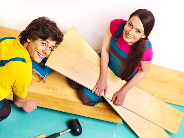 Família que coloca parquet em casa — Fotografia de Stock