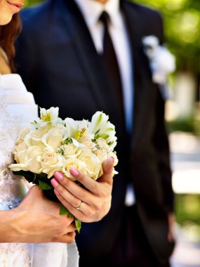 Gelin ve damat çiçek açık tutarak.