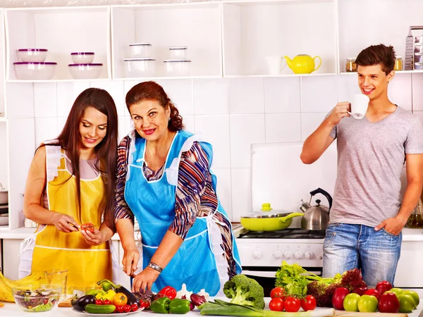Zralá žena s rodinnou připravuje v kuchyni. — Stock fotografie