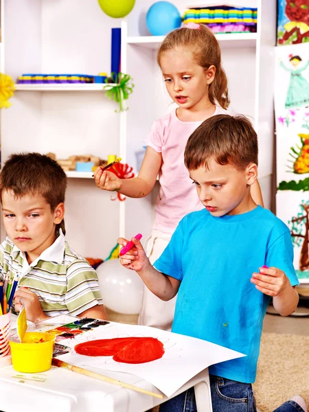 Children painting at easel. — Stock Photo, Image