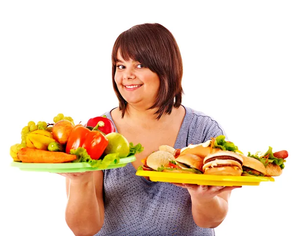 Женщина выбирает между фруктами и гамбургером . — стоковое фото