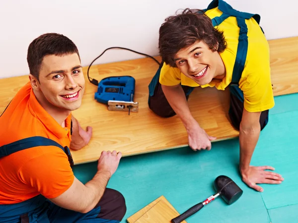 Hombres que ponen parquet en casa — Foto de Stock