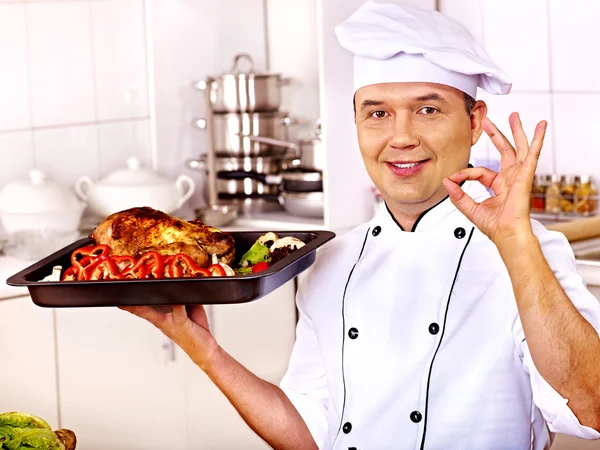 Homem de chapéu de chef cozinhar frango — Fotografia de Stock