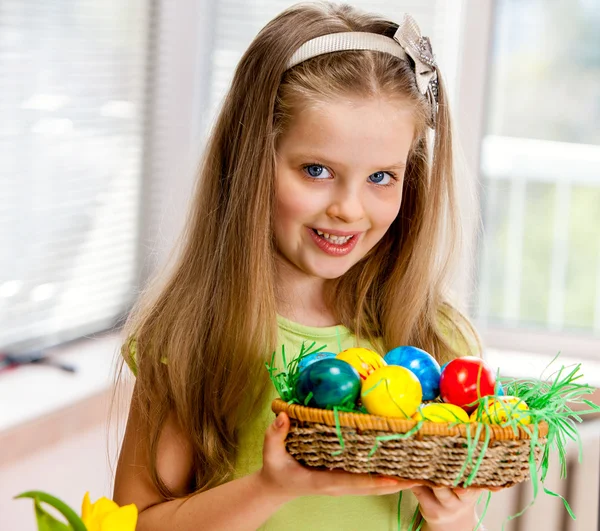 Счастливый ребенок рисует пасхальные яйца дома — стоковое фото