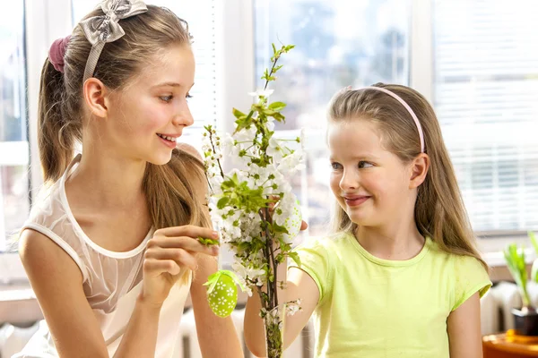 Les enfants accrochent l'oeuf de Pâques sur la branche de cerise . — Photo