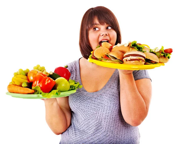 Mujer eligiendo entre fruta y hamburguesa . — Foto de Stock