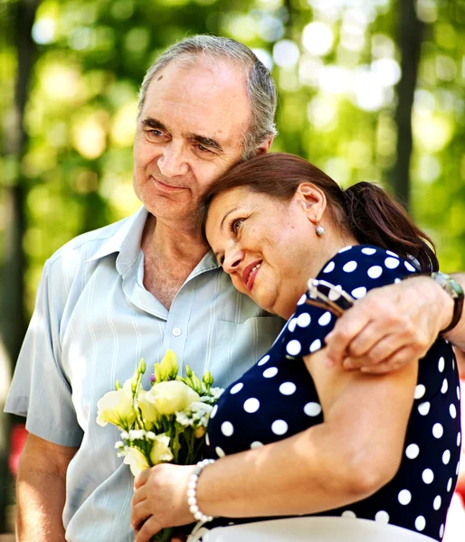 Glückliches altes Paar mit Blume. — Stockfoto