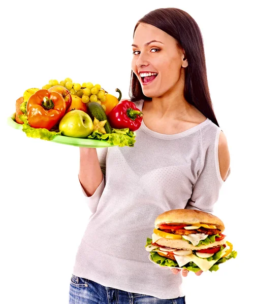 Женщина выбирает между фруктами и гамбургером . — стоковое фото
