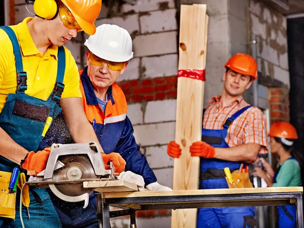 Grupp människor builder med cirkelsåg . — Stockfoto