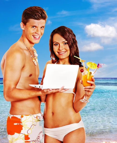 Couple with laptop at beach. — Stock Photo, Image