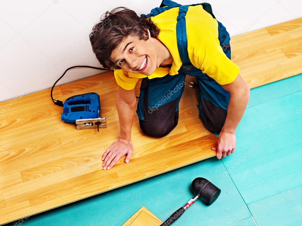 Men laying parquet at home