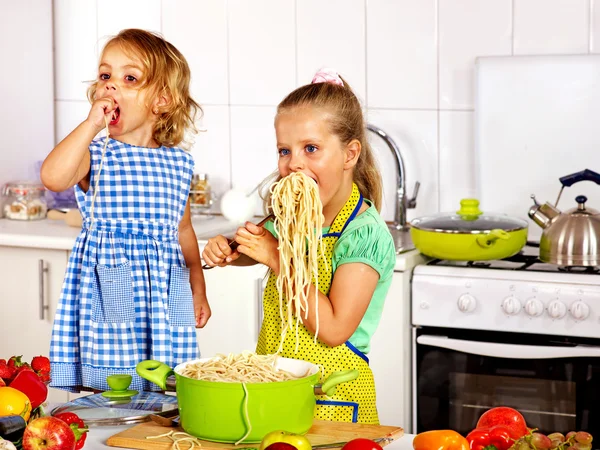 Kinderen eten spaghetti in kitchen — Stockfoto