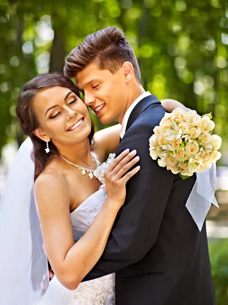 Bride and groom with flowers outdoor. — Stock Photo, Image