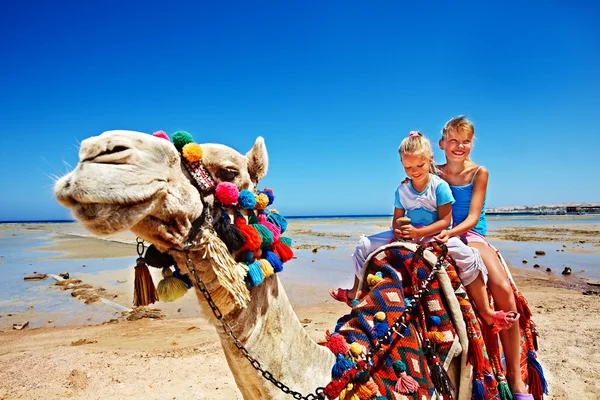 Turisták lovaglás teve Egyiptomról beach. — Stock Fotó