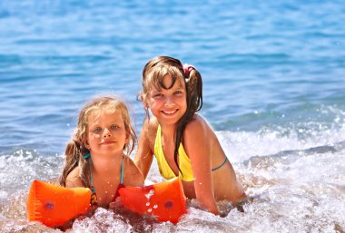 çocuklar kumsalda oynarken.