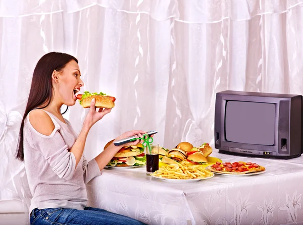 Жінка їсть фастфуд і дивиться телевізор . — стокове фото