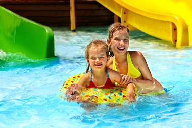 şişme halkada oturan çocuk.