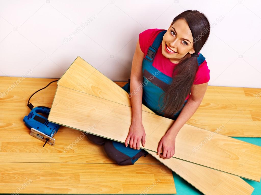 Builder woman with floor planks