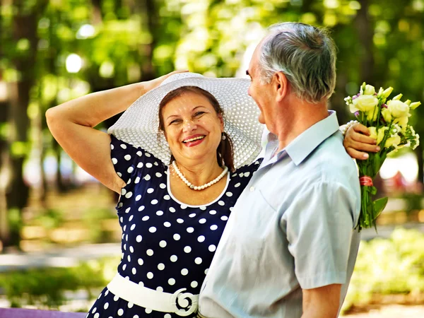 Vieux couple avec des fleurs . — Photo