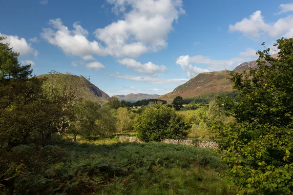 Pohled přes buttermere vesnice vzdálené kopce — Stock fotografie