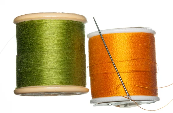 Orange and green bobbins of thread — Stock Photo, Image