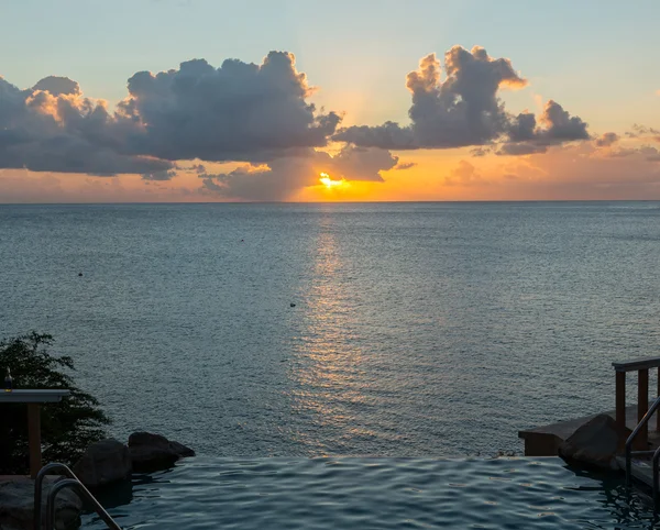 Piscina de borde infinito con mar debajo del atardecer — Foto de Stock