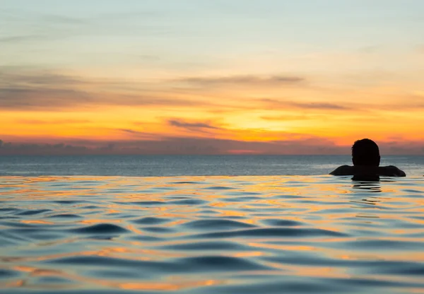 Cabeza de silueta contra piscina de borde infinito — Foto de Stock