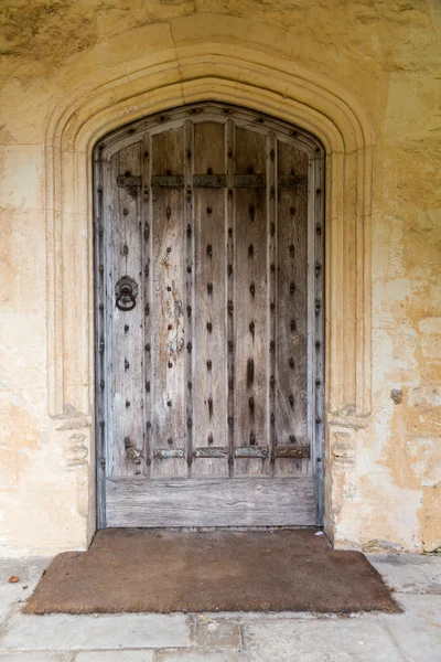 Ancient oak wooden door in stone surround — Stock Photo, Image